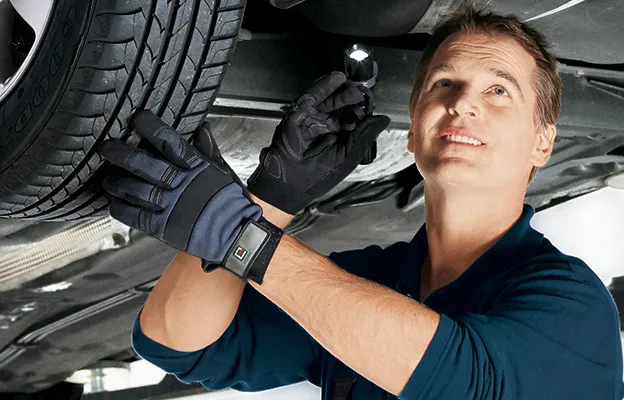 Mechaniker prüft ein Fahrzeug auf der Hebebühne